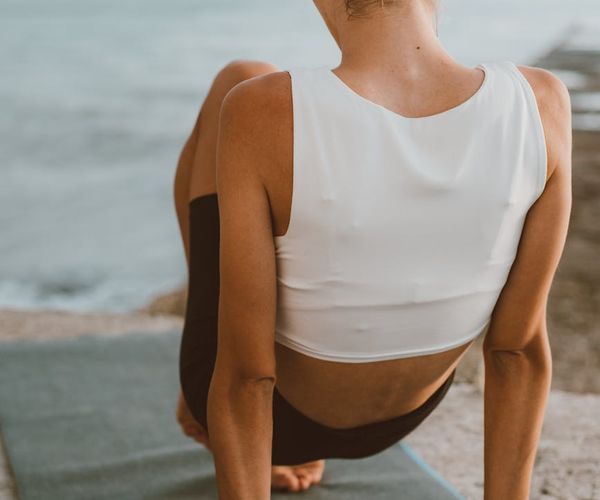 Person stretching gently outdoors during a calm sunrise.